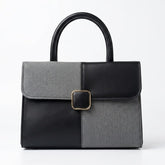 Two-tone black and grey structured satchel bag, front view with gold buckle