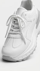 Close-up of white runner sneaker showing wave sole