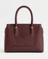 Burgundy structured satchel bag with gold handle bars, front view