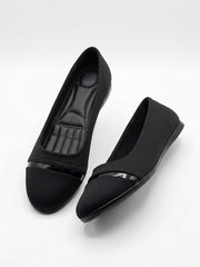 Pair of black pointed ballet flats with patent toe caps, seen from above