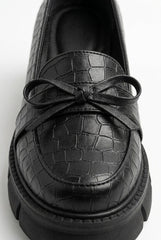 Close-up of the leather bow on the croc-embossed apron toe