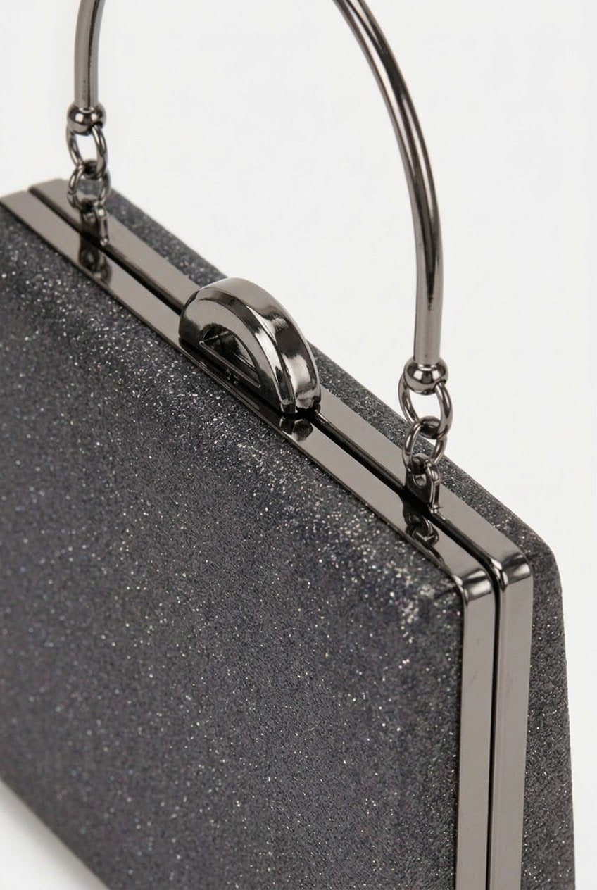 Close-up of black glitter clutch showing silver clasp detail