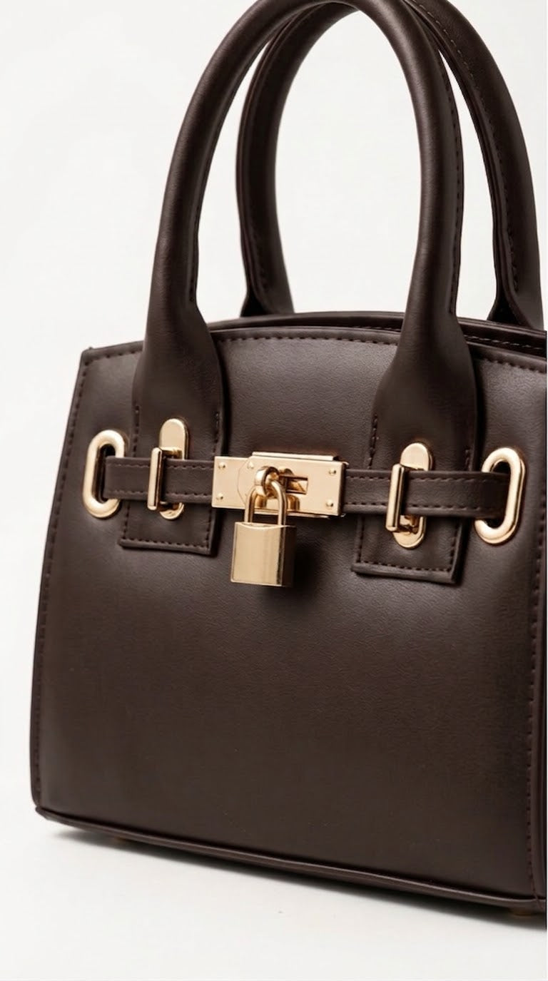 Angled view of brown mini padlock handbag showing gold hardware
