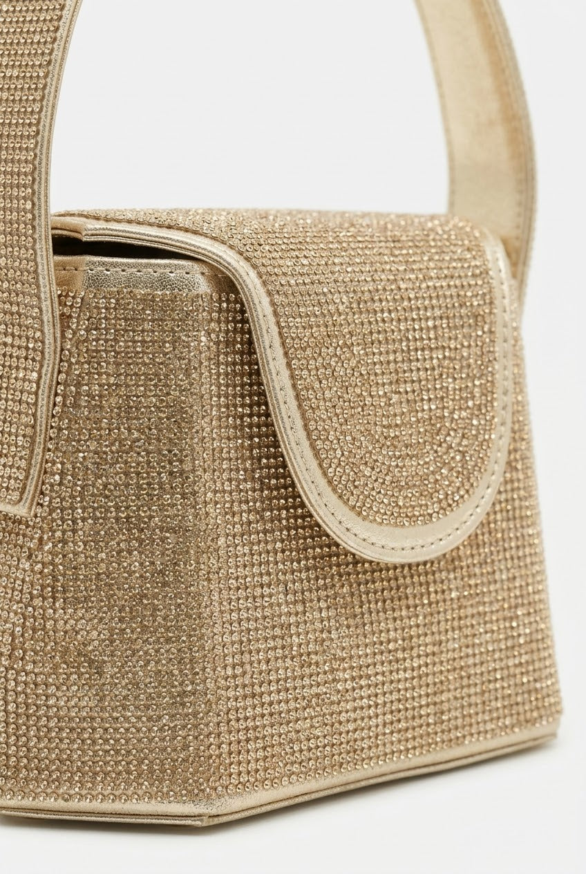 Close-up of gold rhinestone bag showing crystal texture and flap
