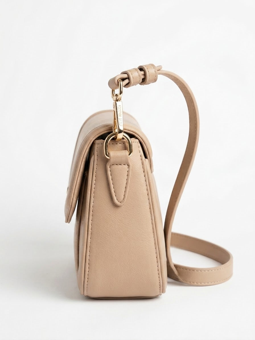Side profile of tan flap shoulder bag with strap