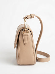 Side profile of tan flap shoulder bag with strap
