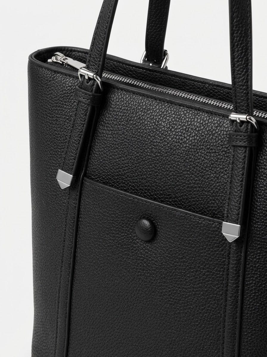 Close-up of black tote showing corner caps and stud detail