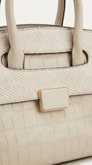 Close-up of cream satchel showing croc and snake embossed texture