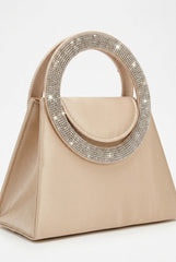 Angled view of nude trapeze bag showing crystal handle and flap