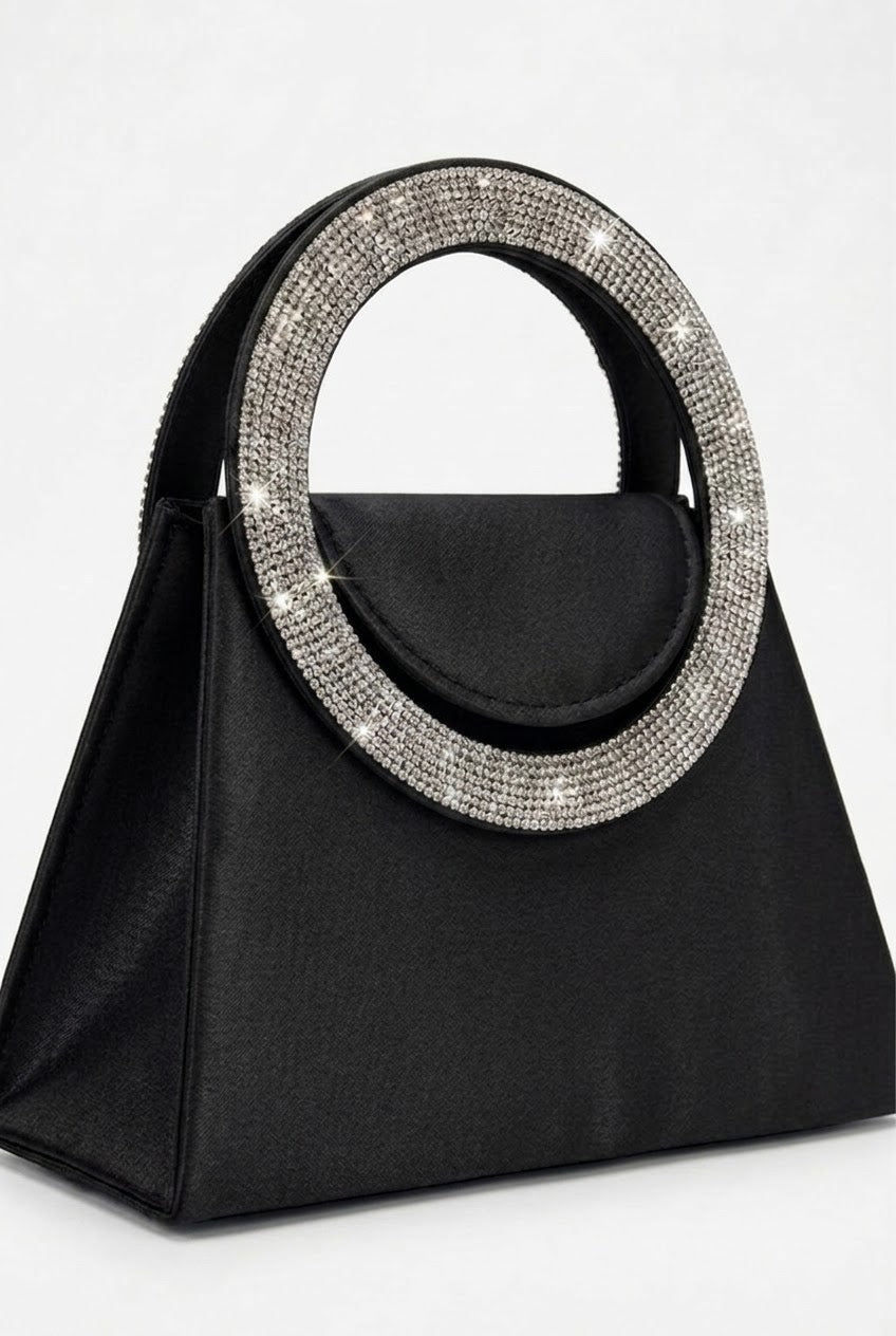 Angled view of black trapeze bag showing crystal handle