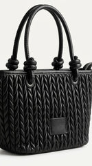 Angled view of black quilted tote showing chevron texture