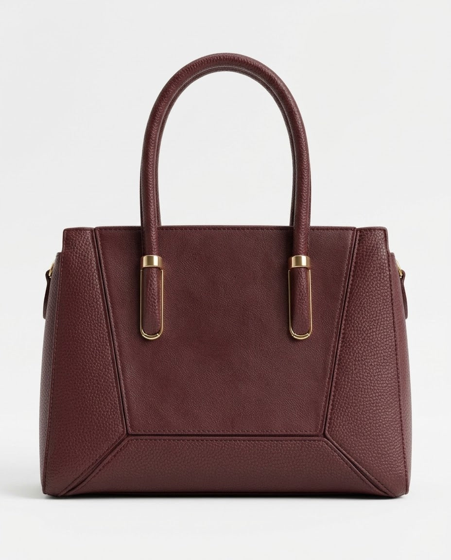Burgundy structured satchel bag with gold handle bars, front view