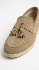 Close-up of camel suede loafer showing tassel detail
