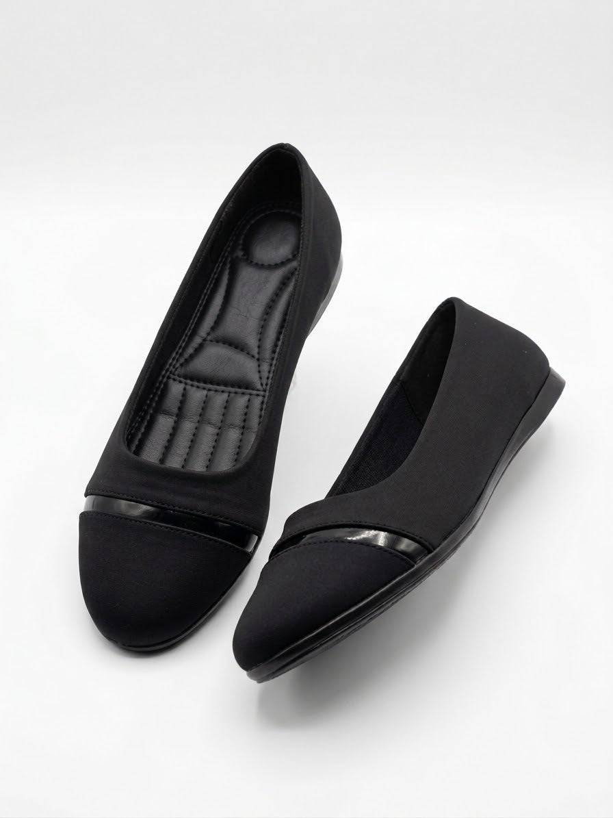 Pair of black pointed ballet flats with patent toe caps, seen from above