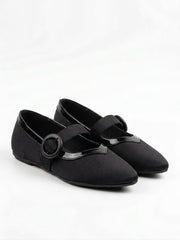 Pair of black Mary Jane flats with round buckle straps, angled view