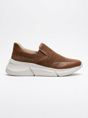 Tan suede and leather slip-on sneaker with a white sole, side view