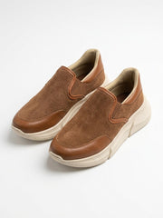Pair of tan suede slip-on sneakers at an angle