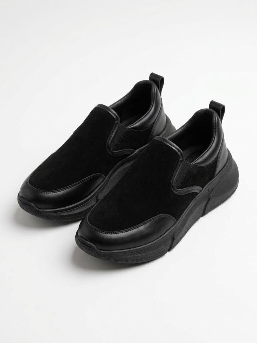 Pair of all-black suede slip-on sneakers at an angle