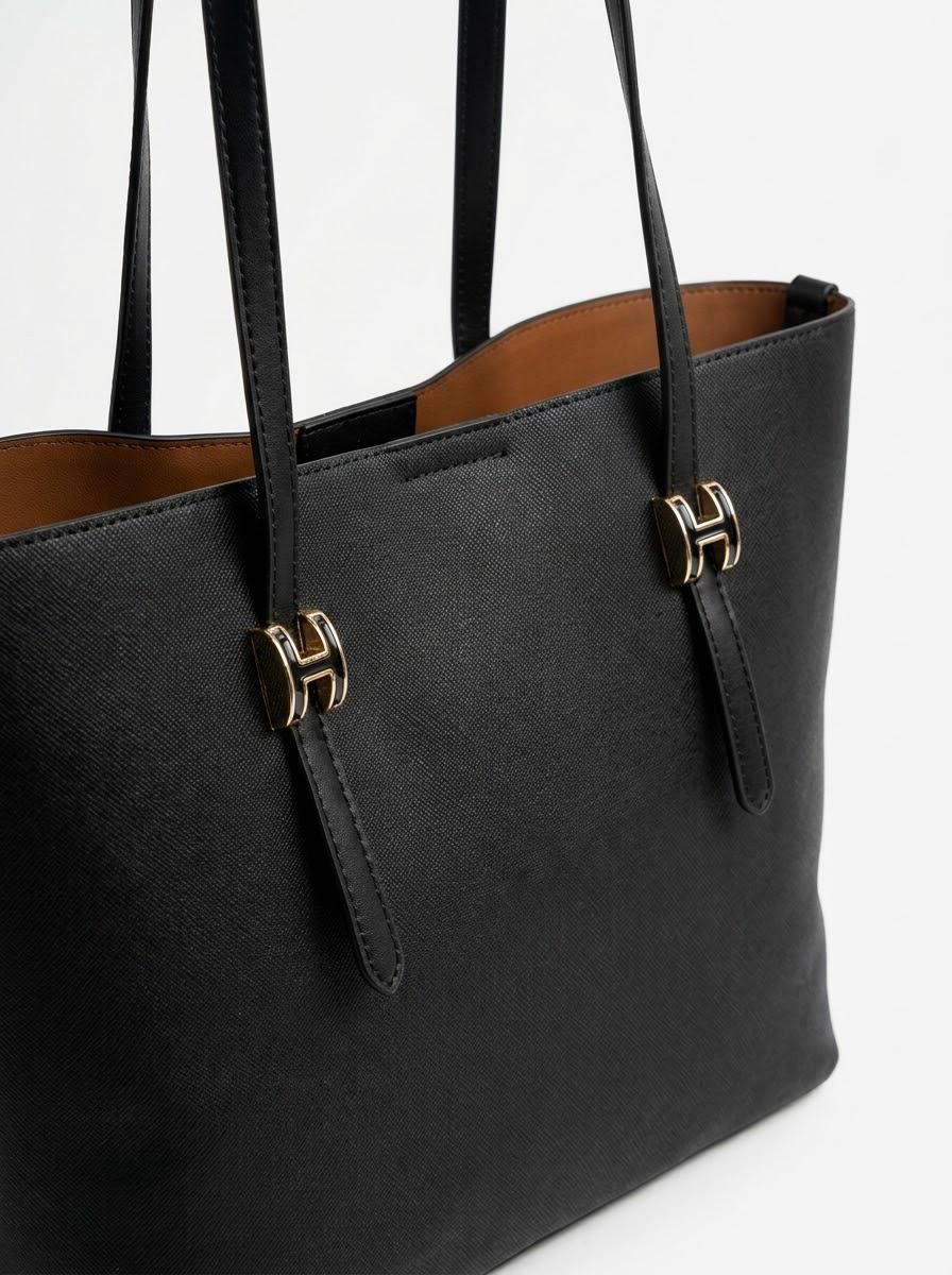 Angled view of Black shopper tote showing buckle hardware