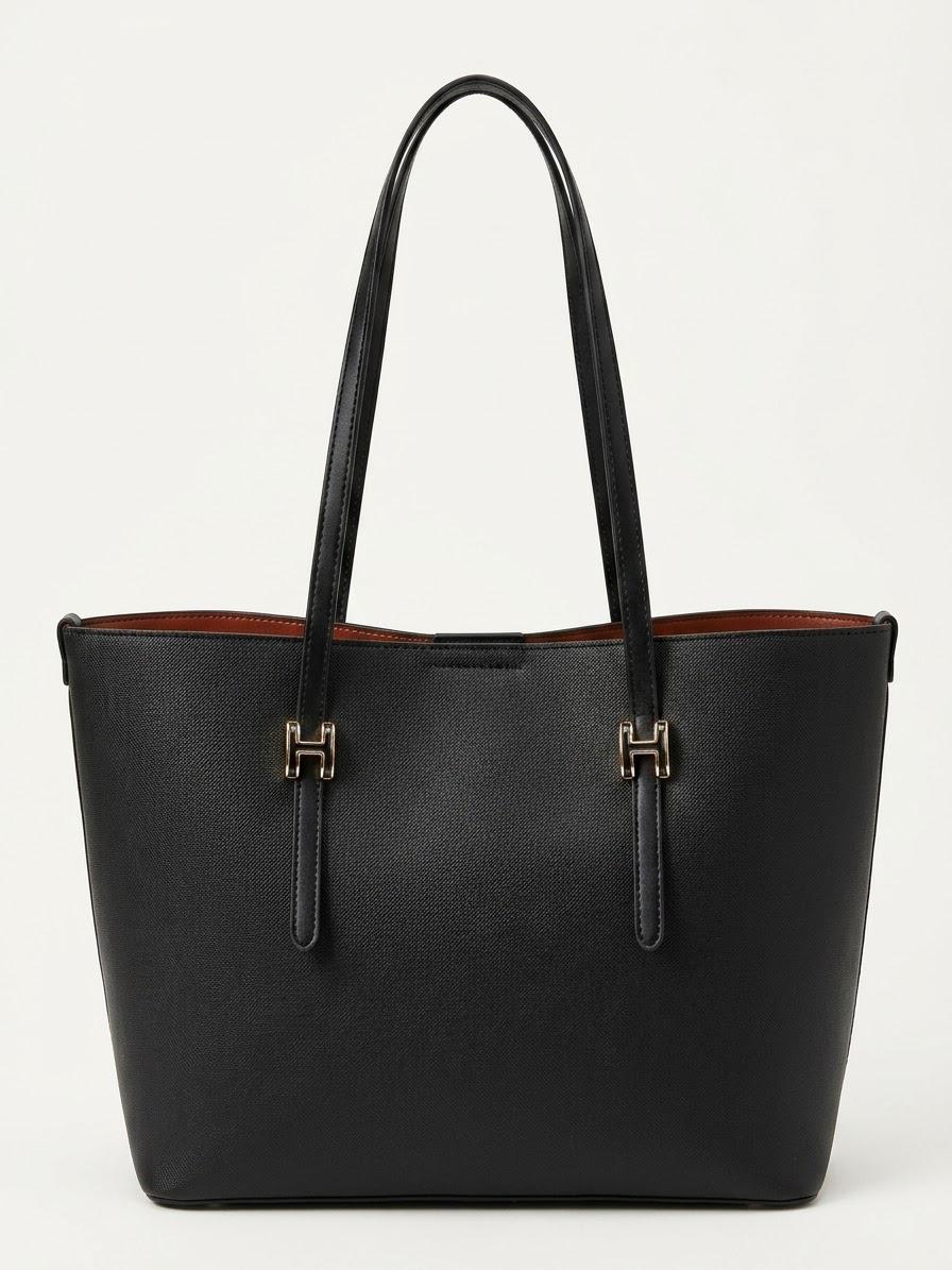 Black textured shopper tote bag with gold buckle straps, front view